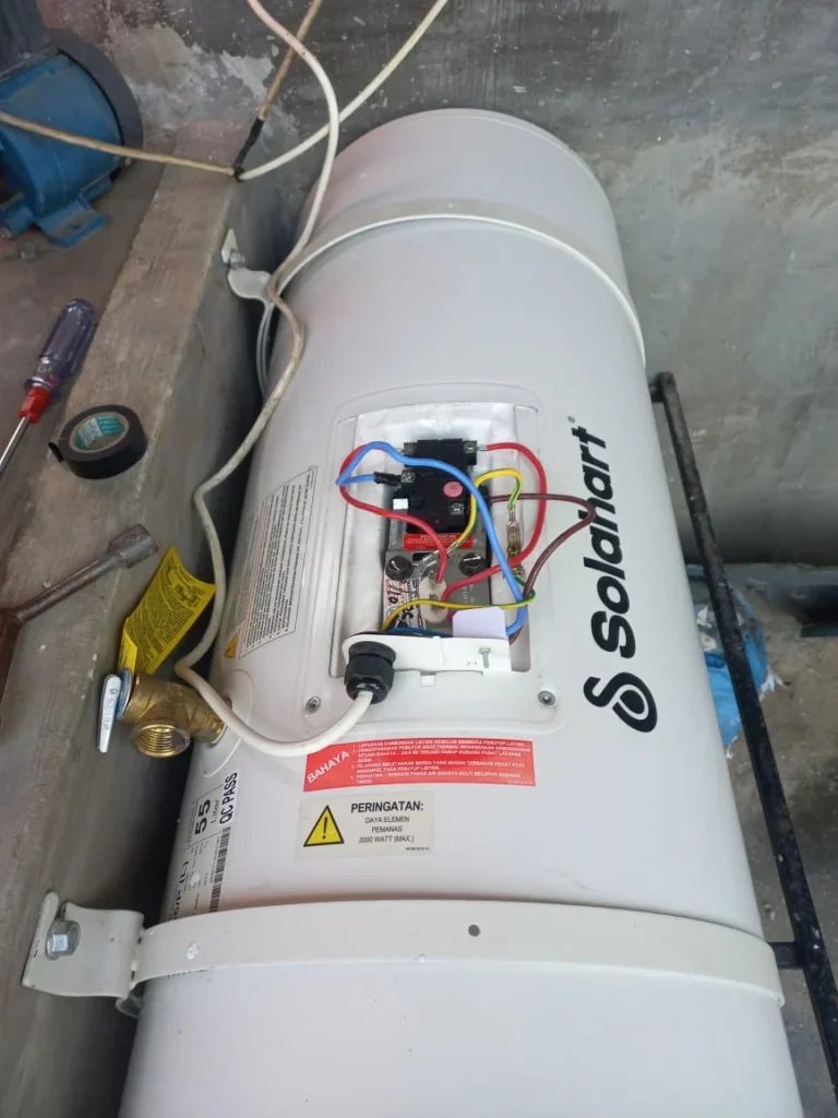 Water heater listrik Solahart dengan thermostat dan kabel terbuka saat diperiksa